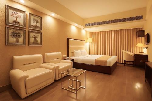 a hotel room with a bed and a chair at Hotel O2 Oxygen in Kolkata
