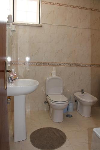 a bathroom with a toilet and a sink at Vina's Place in Nazaré
