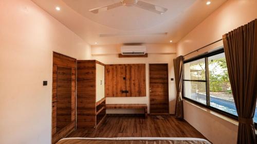 a room with a bench and a window in a house at The Misty Villas Igatpuri by Natura Stays, 6 BHK in Igatpuri