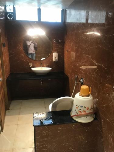 a person taking a picture of a bathroom with a mirror at The Misty Villas Igatpuri by Natura Stays, 6 BHK in Igatpuri