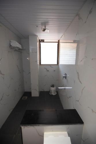 a bathroom with a toilet and a window in it at The Misty Villas Igatpuri by Natura Stays, 6 BHK in Igatpuri