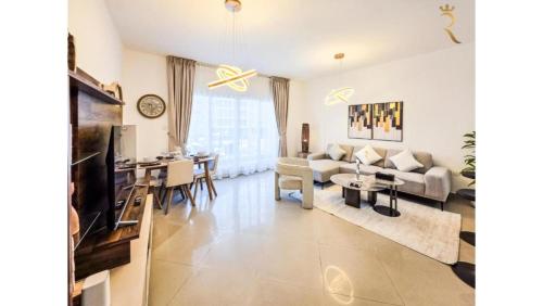 a living room with a couch and a table at Modern 1BR - Poolside & Gym Escape in Abu Dhabi