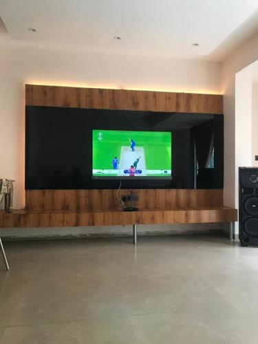 a large flat screen tv on a wooden wall at The Misty Villas Igatpuri by Natura Stays, 6 BHK in Igatpuri