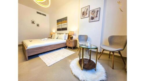 a bedroom with a bed and a table and chairs at Modern 1BR - Poolside & Gym Escape in Abu Dhabi