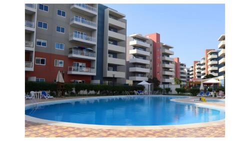 an empty swimming pool in front of some apartment buildings at Modern 1BR - Poolside & Gym Escape in Abu Dhabi