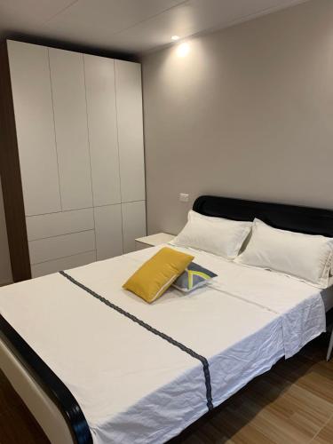 a bed with a yellow pillow on top of it at Ashely apartment 2 bedrrooms in Nadi