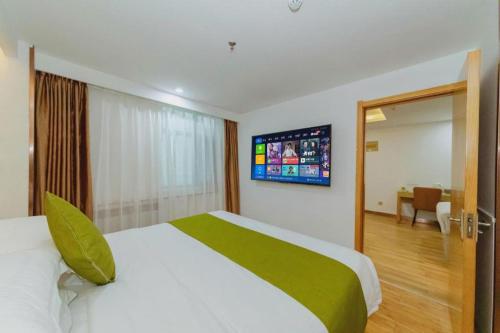 Ένα ή περισσότερα κρεβάτια σε δωμάτιο στο GreenTree Inn High-tech Zone Shandong University Bathing Beach Hotel