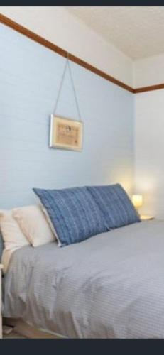 a bedroom with a bed with a blue pillow at Aeris Country Cottage in Junee