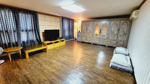 a living room with a tv and a wooden floor at Kyungha Spa Hotel in Daejeon