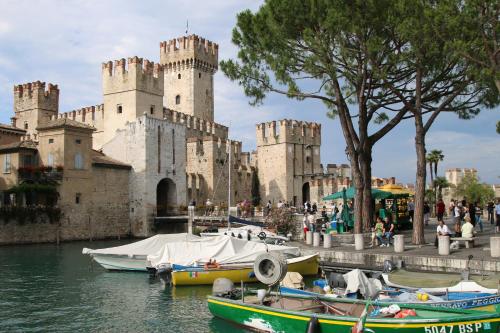 a castle with boats in the water in front of it at Appartamento Cipria in Sirmione