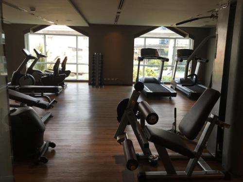 a gym with a row of treadmills and machines at Al Meroz Hotel Bangkok - The Leading Halal Hotel in Bangkok