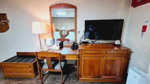 a room with a desk with a television and a mirror at Kyungha Spa Hotel in Daejeon