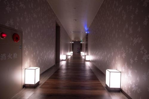a hallway with lights on the walls of a building at Hotel S in Nara