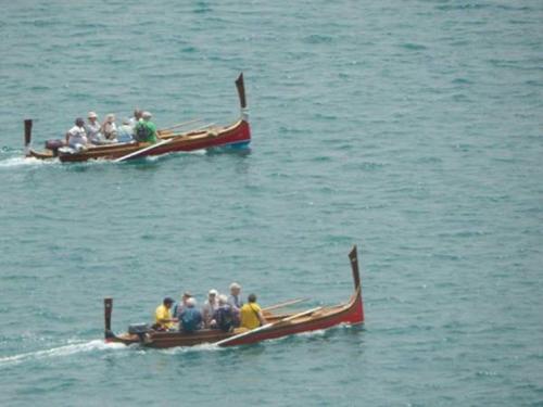 two groups of people in boats in the water at Valletta Harbour View Apartment in Valletta