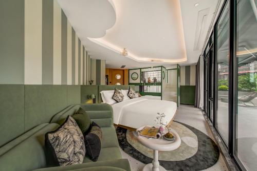 a hotel room with a bed and a couch and a table at 珠海复登临酒店 Relanding Hotel in Zhuhai