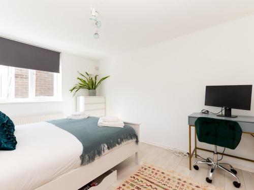 a bedroom with a bed and a desk with a television at Pass the Keys Charming Tranquil 2 BR Kingston Escape London in Kingston upon Thames