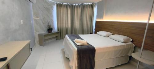 a hotel room with a bed and a bathroom at Victory Tambaú in João Pessoa