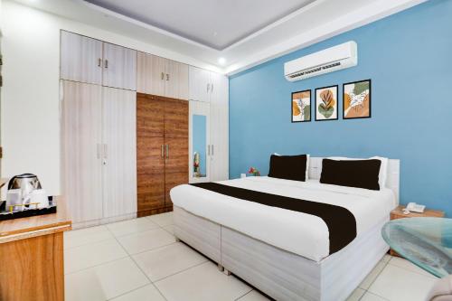 a bedroom with a large bed and a blue wall at Super Townhouse Subhash Chowk Near Medanta Hospital Formerly L B Residency in Gurgaon