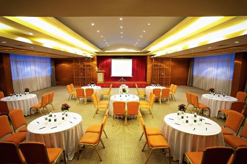 a conference room with tables and chairs and a screen at Muong Thanh Holiday Da Lat Hotel in Da Lat