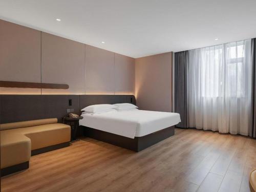 a bedroom with a large bed and a window at Jinjiang Inn Quanzhou West Street Kaiyuan Temple in Quanzhou