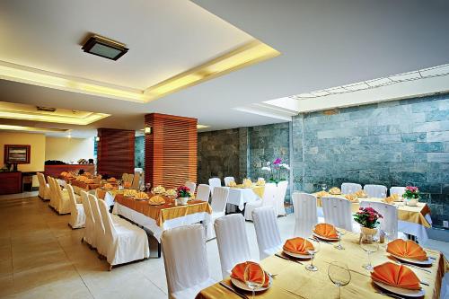a banquet hall with white tables and white chairs at Muong Thanh Holiday Da Lat Hotel in Da Lat