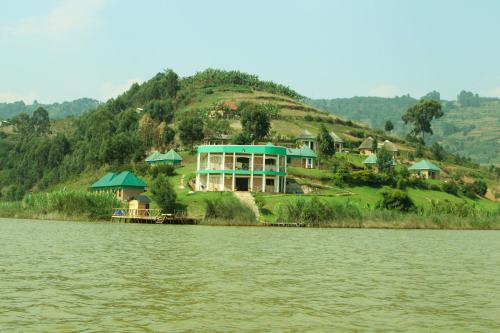 a large house on a hill next to the water at Nyamunyonyi Lake Resort in Kabale
