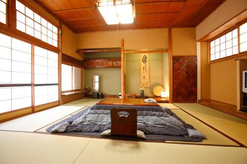 ein Zimmer mit einem großen Bett in der Mitte in der Unterkunft Shimizu Ryokan in Yufu
