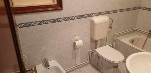a bathroom with a toilet and a sink at Piso de Perlío, ideal para gente amante de la pla in Fene
