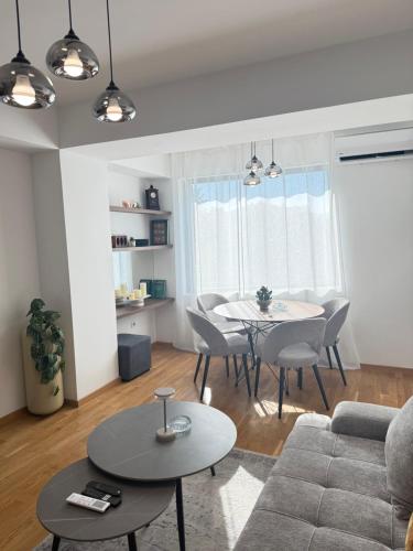 a living room with a couch and a table and chairs at Skopje Stefanovi apartments in Skopje