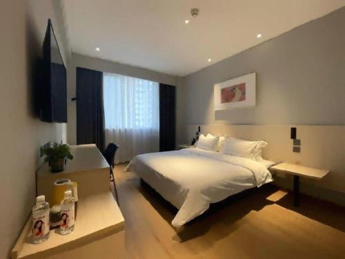 a bedroom with a large white bed and a window at Jinjiang Inn Huizhou Xihu Lake Shuidong Street River View in Huizhou