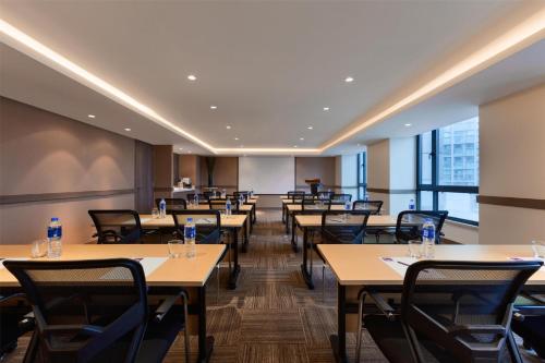 a dining room with tables and chairs and windows at Hyatt Place Shenzhen Dongmen in Shenzhen