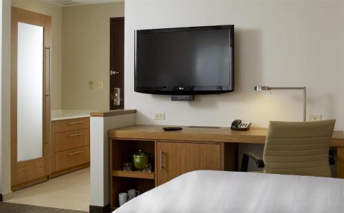 a hotel room with a desk with a television on the wall at Hyatt Place Shenzhen Dongmen in Shenzhen