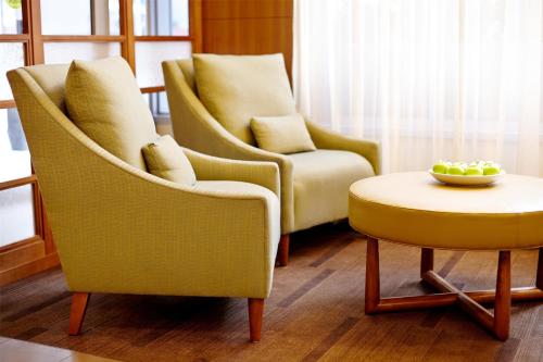 a living room with two chairs and a bowl of fruit on a table at Hyatt Place Shenzhen Dongmen in Shenzhen