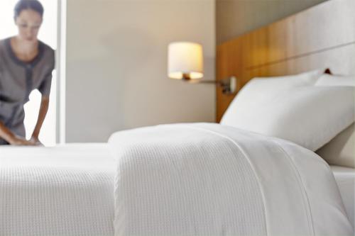 a man is standing next to a bed in a hotel room at Hyatt Place Shenzhen Dongmen in Shenzhen