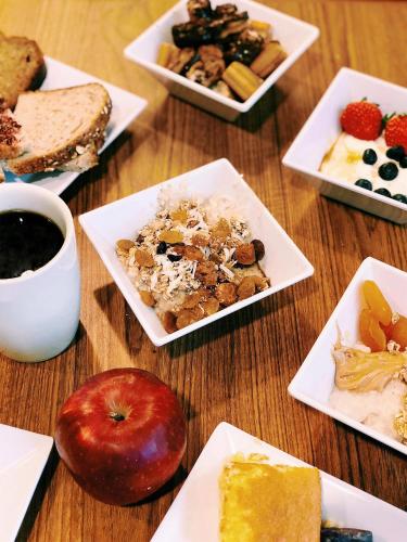 a wooden table with plates of food and an apple at Hyatt Place Shenzhen Dongmen in Shenzhen
