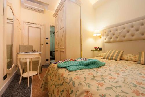 a bedroom with a bed and a table and a desk at Hotel Astigiana & Appartamenti in Varazze