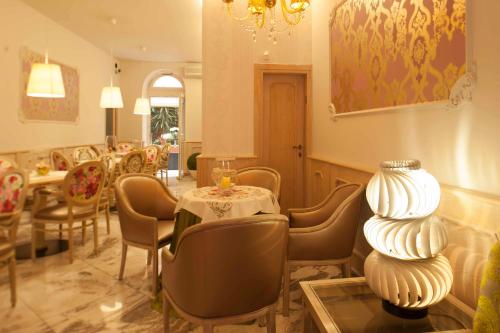 a restaurant with a table and chairs and a chandelier at Hotel Astigiana & Appartamenti in Varazze
