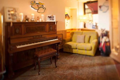 a living room with a piano and a couch at Hotel Astigiana & Appartamenti in Varazze