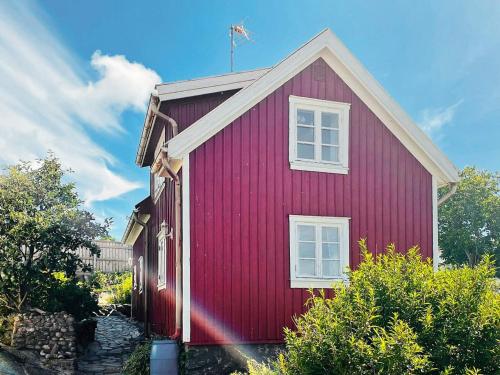 a red house with a flag on top of it at 4 person holiday home in Rönnäng-By Traum in Rönnäng