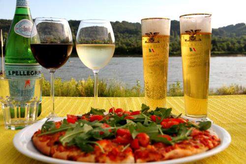a table with a plate of pizza and two glasses of wine at Rheinhotel Bellavista in Braubach