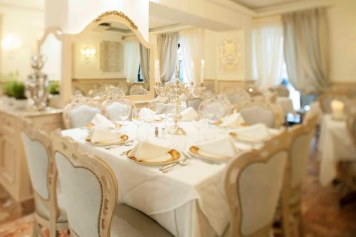 a dining room with a white table and chairs at Hotel Astigiana & Appartamenti in Varazze