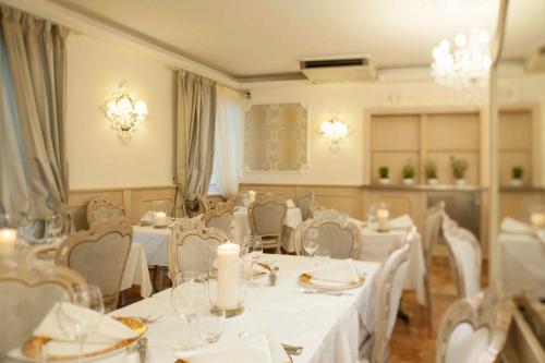 a dining room with white tables and chairs at Hotel Astigiana & Appartamenti in Varazze