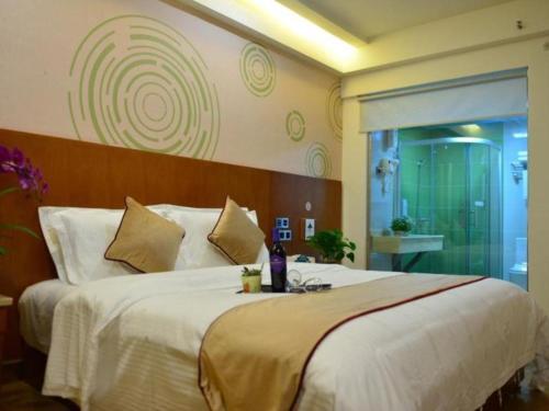 a bedroom with a large bed in a room at GreenTree Inn Qingdao Jiaozhou Jiaoping Road Express Hotel in Qingdao