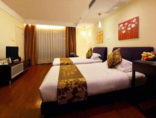 a hotel room with two beds and a television at Kingtown Hotel Hongqiao Shanghai in Shanghai