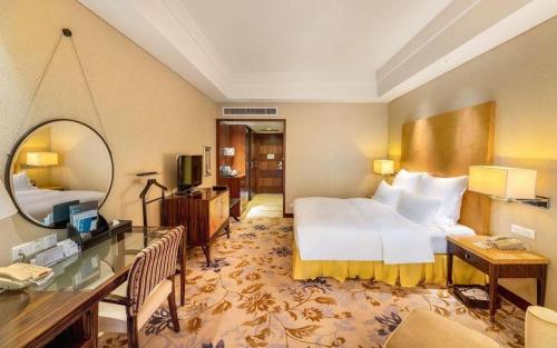 a hotel room with a bed and a mirror at Kunshan Newport Hotel in Suzhou