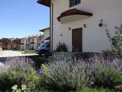 a building with purple flowers in front of it at Pinerose Resort in Bansko