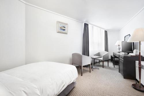 Ένα ή περισσότερα κρεβάτια σε δωμάτιο στο Hotel President