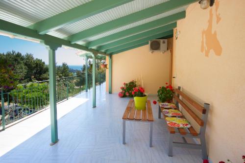 a patio with a table and a bench on a balcony at Maria Apartments in Lourdhata