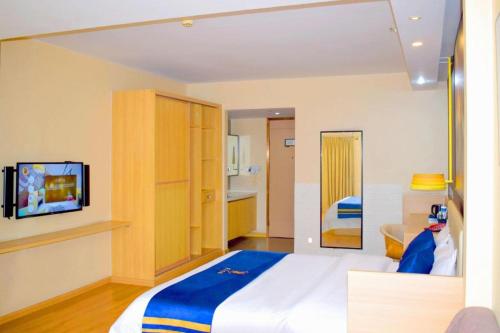a bedroom with a large white bed and a tv at IU Hotel Chengdu High-Tech Zone Longhu Times Street in Chengdu