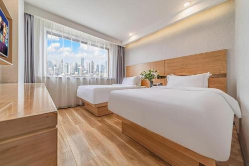a hotel room with two beds and a window at GreenTree Inn Haixi Geermu Southern suburbs Express Hotel in Golmud